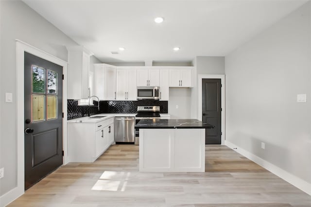 4719 Mallow St, Houston, TX 77033 - kitchen featuring appliances with stainless steel finishes, white cabinetry, light wood-style flooring, and recessed lighting