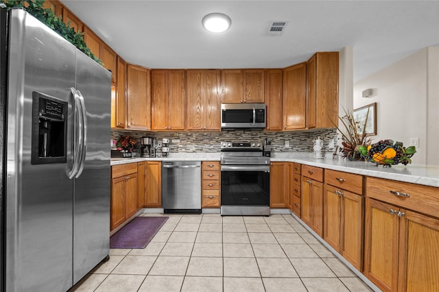 413 Susan St, Lufkin, TX 75901 - kitchen with stainless steel appliances, light countertops, brown cabinets, and tasteful backsplash
