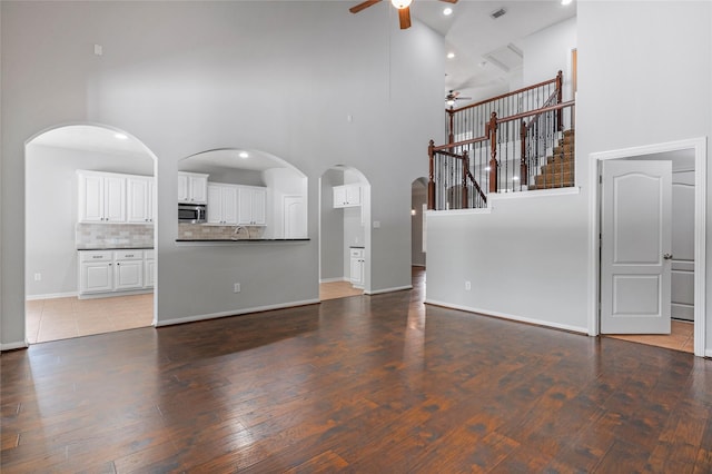 25303 Hall Meadow Ln, Katy, TX 77494 - unfurnished living room with ceiling fan, a high ceiling, wood finished floors, recessed lighting, and arched walkways