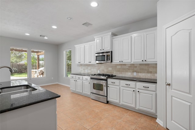 25303 Hall Meadow Ln, Katy, TX 77494 - kitchen with stainless steel appliances, backsplash, white cabinets, light tile patterned floors, and recessed lighting