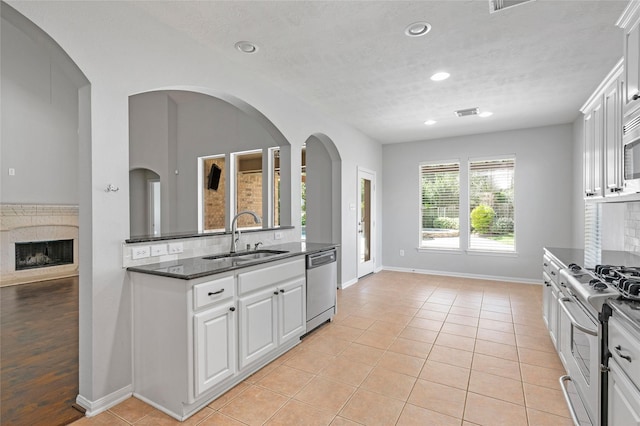 25303 Hall Meadow Ln, Katy, TX 77494 - kitchen featuring appliances with stainless steel finishes, white cabinets, recessed lighting, light tile patterned flooring, and tasteful backsplash