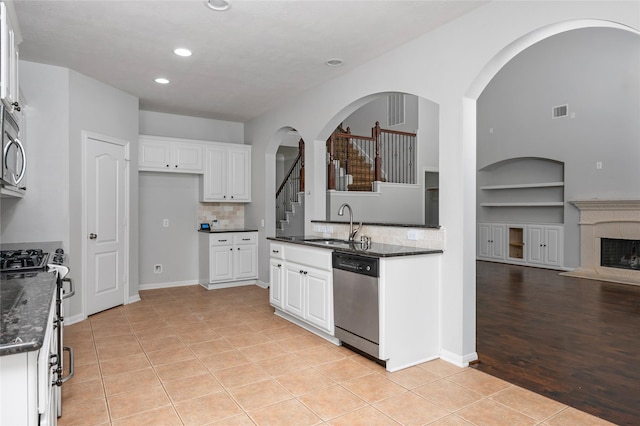 25303 Hall Meadow Ln, Katy, TX 77494 - kitchen featuring appliances with stainless steel finishes, built in features, recessed lighting, white cabinetry, and arched walkways