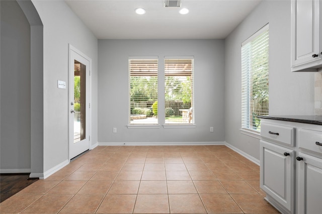 25303 Hall Meadow Ln, Katy, TX 77494 - unfurnished dining area with arched walkways, light tile patterned floors, and recessed lighting