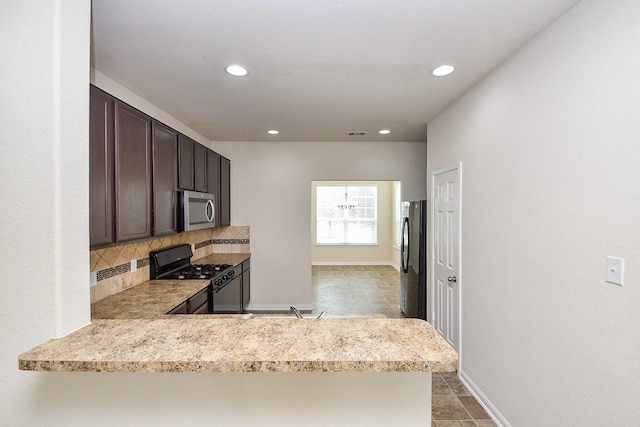 15315 Signal Ridge Way, Cypress, TX 77429 - kitchen featuring black appliances, dark brown cabinetry, tasteful backsplash, recessed lighting, and a peninsula