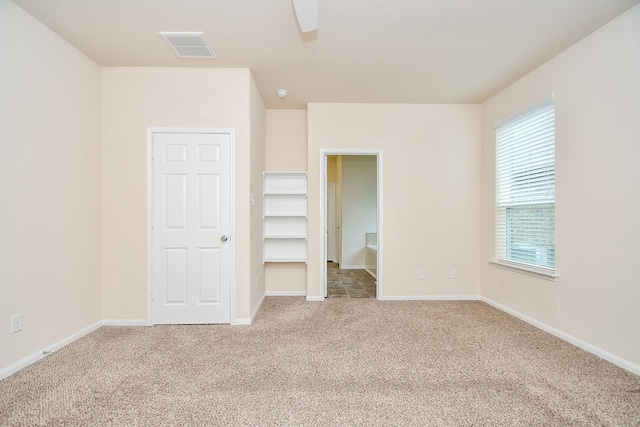 15315 Signal Ridge Way, Cypress, TX 77429 - unfurnished bedroom with light carpet, multiple windows, a walk in closet, and ceiling fan