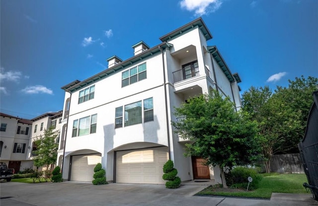 5708 Dolores St Unit A, Houston, TX 77057 - view of property with stucco siding, a garage, concrete driveway, and a balcony