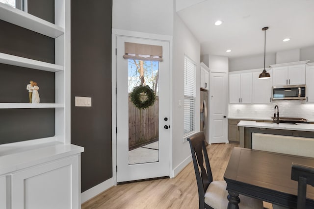5361 Creekmont Oaks Ln, Houston, TX 77091 - kitchen featuring appliances with stainless steel finishes, light wood finished floors, light countertops, white cabinetry, and recessed lighting
