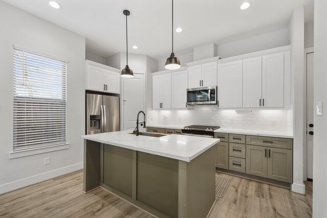 5361 Creekmont Oaks Ln, Houston, TX 77091 - kitchen featuring appliances with stainless steel finishes, decorative backsplash, light wood-style flooring, white cabinets, and recessed lighting