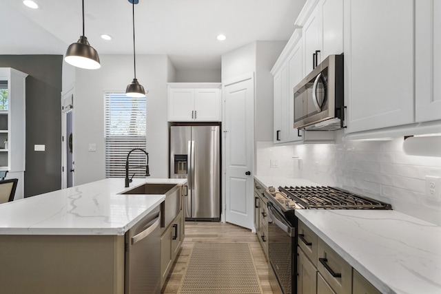 5361 Creekmont Oaks Ln, Houston, TX 77091 - kitchen with stainless steel appliances, tasteful backsplash, light wood-type flooring, an island with sink, and hanging light fixtures
