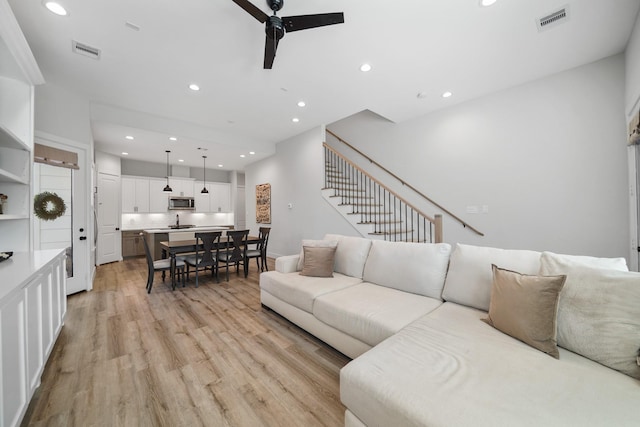5361 Creekmont Oaks Ln, Houston, TX 77091 - living room featuring a ceiling fan, light wood finished floors, recessed lighting, and stairway