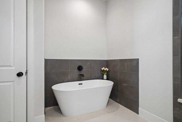 5361 Creekmont Oaks Ln, Houston, TX 77091 - bathroom with a freestanding bath, tile walls, and wainscoting