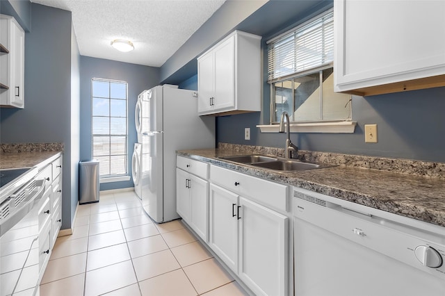 12550 Whittington Dr Unit 814, Houston, TX 77077 - kitchen featuring white appliances, dark countertops, white cabinets, a textured ceiling, and light tile patterned flooring