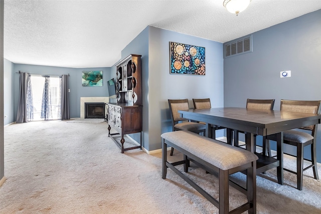 12550 Whittington Dr Unit 814, Houston, TX 77077 - dining room featuring light colored carpet, a textured ceiling, and a high end fireplace