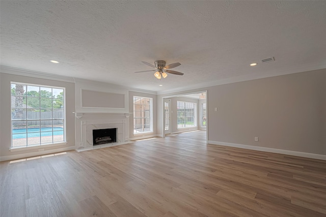 7419 Foxton Place Ct, Houston, TX 77095 - unfurnished living room with a textured ceiling, a ceiling fan, light wood finished floors, crown molding, and healthy amount of natural light