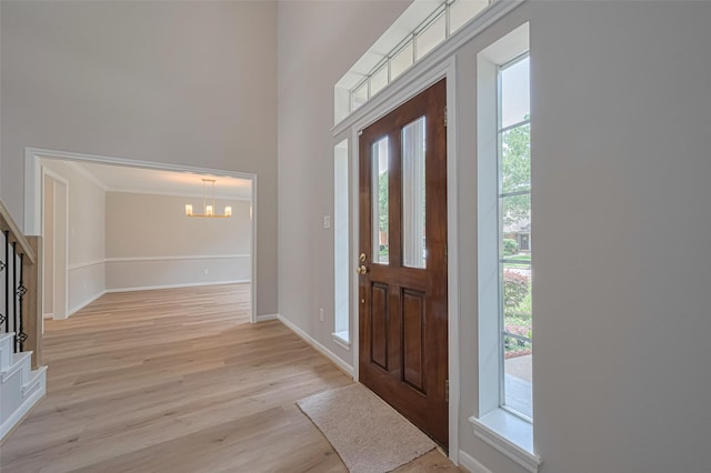 7419 Foxton Place Ct, Houston, TX 77095 - foyer featuring a chandelier, light wood-style floors, stairs, and crown molding