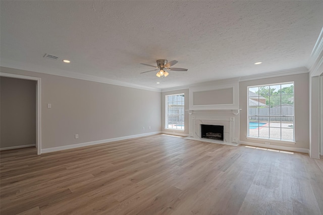 7419 Foxton Place Ct, Houston, TX 77095 - unfurnished living room with crown molding, plenty of natural light, ceiling fan, a textured ceiling, and light wood-style flooring