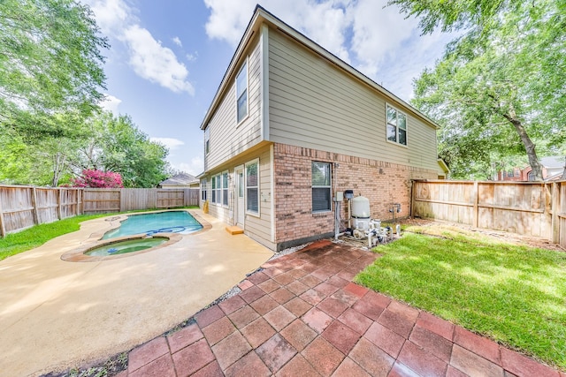 18426 Stark Point Ct, Humble, TX 77346 - back of property with brick siding, a patio area, a fenced backyard, and an in-ground hot tub