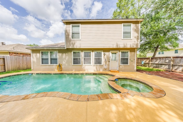 18426 Stark Point Ct, Humble, TX 77346 - rear view of property featuring an in-ground hot tub, a fenced backyard, and a patio area