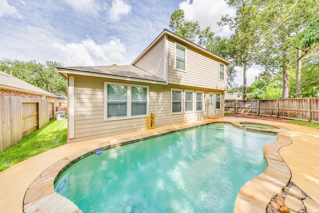 18426 Stark Point Ct, Humble, TX 77346 - rear view of property with a fenced backyard, a pool with connected hot tub, a shingled roof, and a patio area