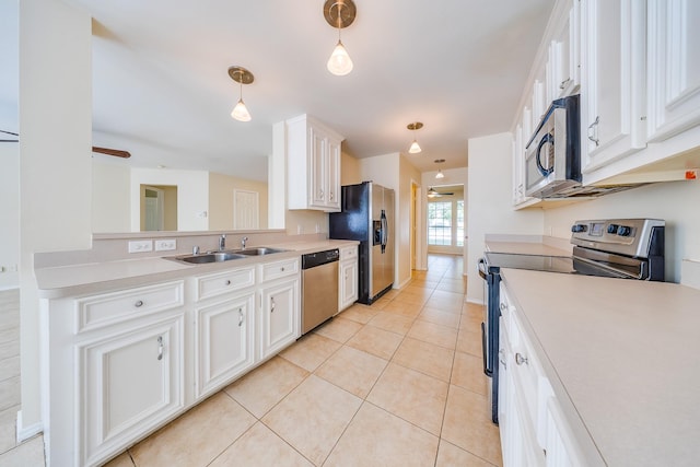 18426 Stark Point Ct, Humble, TX 77346 - kitchen with stainless steel appliances, light tile patterned floors, white cabinets, light countertops, and pendant lighting