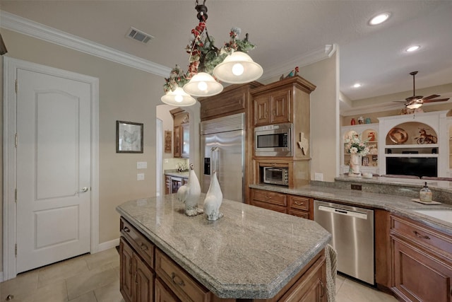69 W Shore Ln, Montgomery, TX 77356 - kitchen featuring built in appliances, brown cabinets, a kitchen island, light stone counters, and a ceiling fan