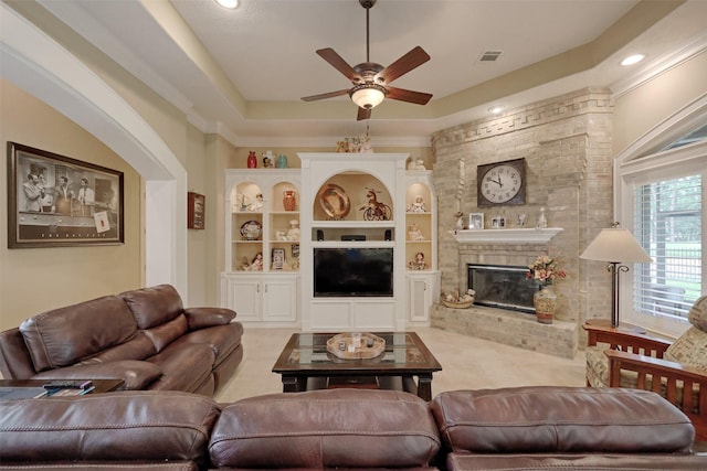69 W Shore Ln, Montgomery, TX 77356 - living room with a ceiling fan, a brick fireplace, a tray ceiling, recessed lighting, and light carpet