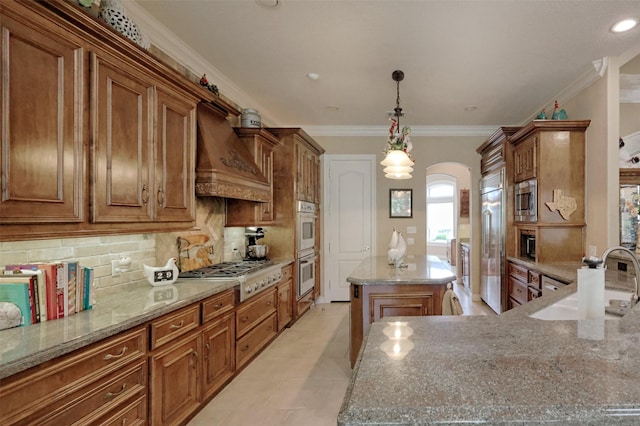 69 W Shore Ln, Montgomery, TX 77356 - kitchen featuring built in appliances, premium range hood, a center island, arched walkways, and decorative backsplash