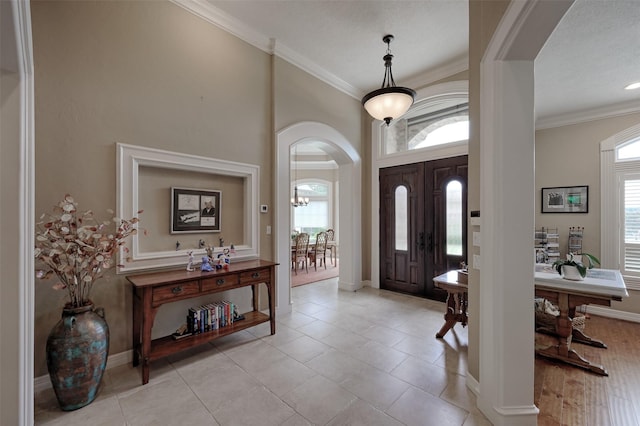 69 W Shore Ln, Montgomery, TX 77356 - entryway featuring arched walkways, plenty of natural light, ornamental molding, and light tile patterned flooring