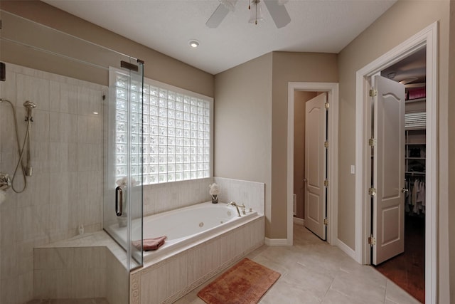 69 W Shore Ln, Montgomery, TX 77356 - full bath featuring a shower stall, a whirlpool tub, a ceiling fan, tile patterned flooring, and a spacious closet