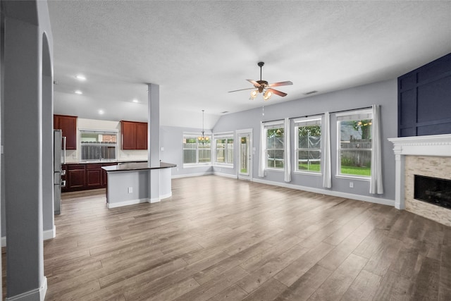 13315 Lake Passage Ln, Houston, TX 77044 - unfurnished living room featuring ceiling fan, a fireplace, wood finished floors, a textured ceiling, and recessed lighting