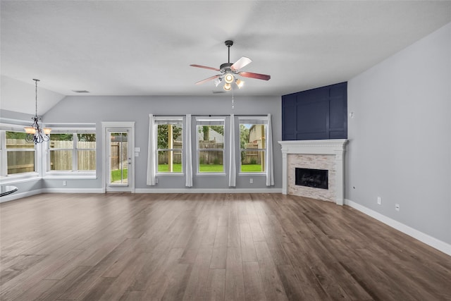 13315 Lake Passage Ln, Houston, TX 77044 - unfurnished living room featuring ceiling fan, wood finished floors, a stone fireplace, lofted ceiling, and a chandelier