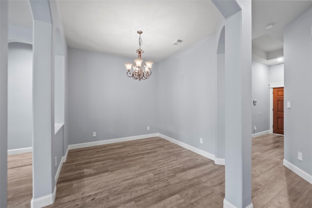 13315 Lake Passage Ln, Houston, TX 77044 - spare room featuring wood finished floors, a chandelier, and arched walkways