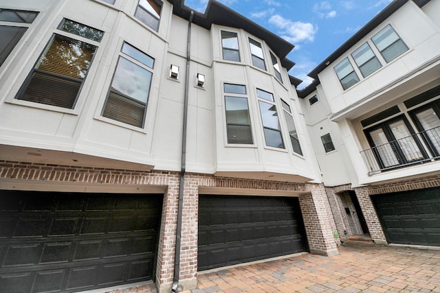 5617 Kiam St Unit A, Houston, TX 77007 - view of property exterior featuring brick siding, a garage, and stucco siding
