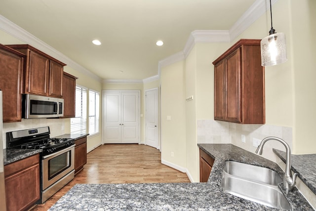 5617 Kiam St Unit A, Houston, TX 77007 - kitchen featuring stainless steel appliances, light wood-style flooring, backsplash, ornamental molding, and hanging light fixtures
