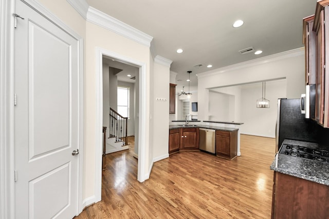5617 Kiam St Unit A, Houston, TX 77007 - kitchen with stainless steel appliances, a peninsula, crown molding, light wood finished floors, and hanging light fixtures