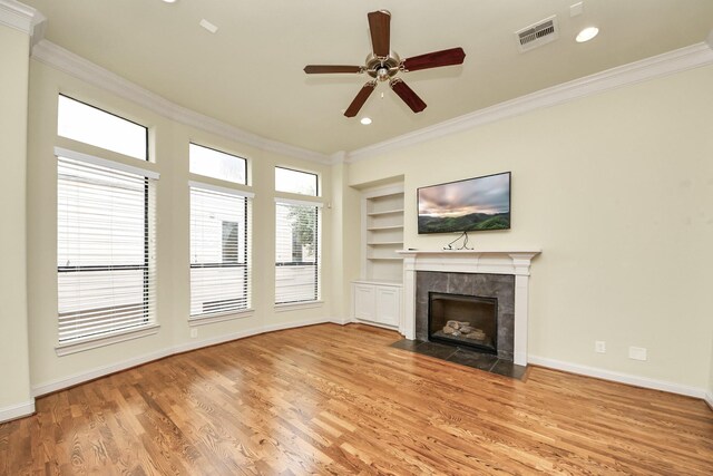 5617 Kiam St Unit A, Houston, TX 77007 - unfurnished living room featuring crown molding, built in features, a tiled fireplace, wood finished floors, and a ceiling fan