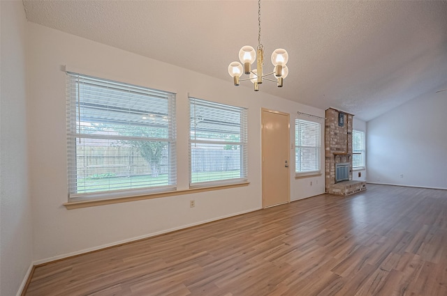 5615 Briarwood Forest Dr, Houston, TX 77088 - unfurnished living room featuring a chandelier, lofted ceiling, wood finished floors, a large fireplace, and a textured ceiling