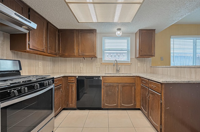 5615 Briarwood Forest Dr, Houston, TX 77088 - kitchen with stainless steel gas range, dishwasher, range hood, a peninsula, and light tile patterned floors