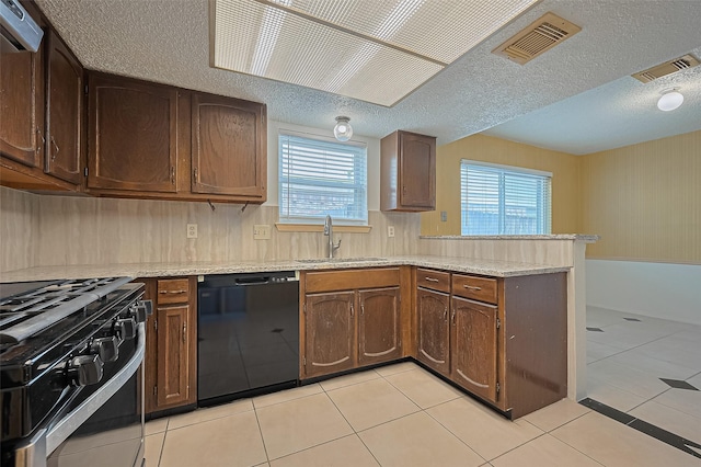 5615 Briarwood Forest Dr, Houston, TX 77088 - kitchen featuring black appliances, a peninsula, healthy amount of natural light, range hood, and a textured ceiling