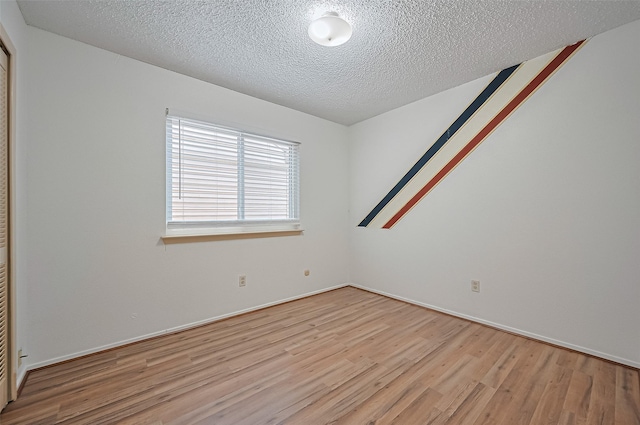 5615 Briarwood Forest Dr, Houston, TX 77088 - spare room featuring light wood-type flooring and a textured ceiling
