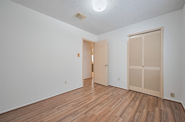 5615 Briarwood Forest Dr, Houston, TX 77088 - unfurnished bedroom featuring wood finished floors, a closet, and a textured ceiling