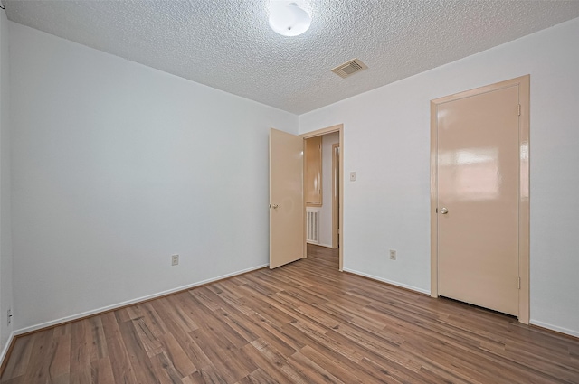 5615 Briarwood Forest Dr, Houston, TX 77088 - spare room featuring wood finished floors and a textured ceiling