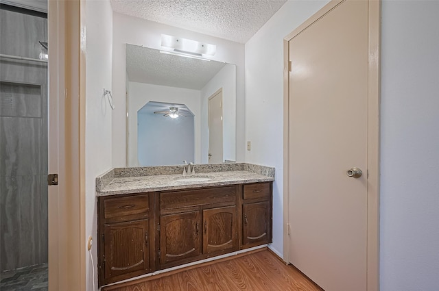 5615 Briarwood Forest Dr, Houston, TX 77088 - bathroom with a textured ceiling, vanity, wood finished floors, and ceiling fan