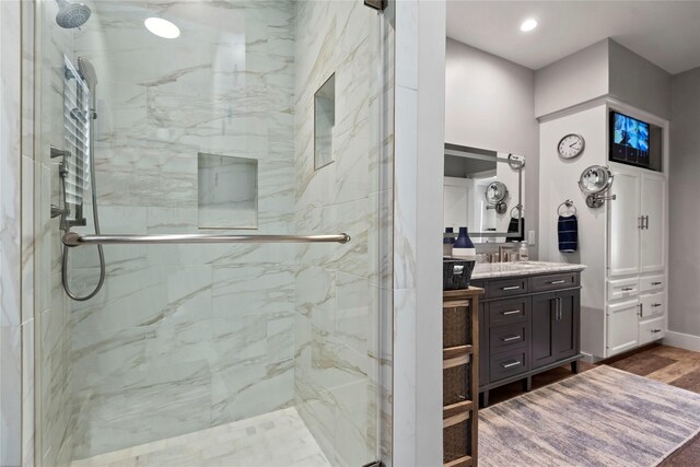 5411 Holly View Dr, Houston, TX 77091 - bathroom featuring a marble finish shower, vanity, wood finished floors, and recessed lighting