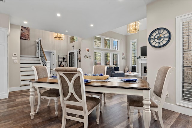 5411 Holly View Dr, Houston, TX 77091 - dining area with a chandelier, stairway, wood finished floors, recessed lighting, and a warm lit fireplace