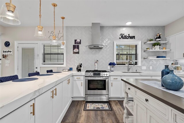 5411 Holly View Dr, Houston, TX 77091 - kitchen with stainless steel gas range, wall chimney exhaust hood, decorative backsplash, white cabinetry, and dark wood-style flooring