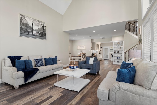5411 Holly View Dr, Houston, TX 77091 - living area featuring stairway, high vaulted ceiling, dark wood finished floors, built in shelves, and recessed lighting