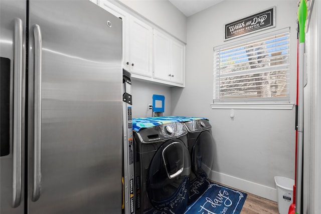5411 Holly View Dr, Houston, TX 77091 - washroom featuring washing machine and clothes dryer, cabinet space, and wood finished floors
