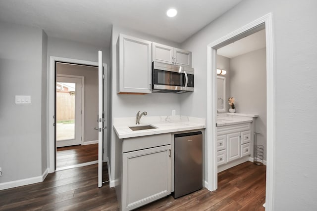 3111 Tanglebriar Dr, Pasadena, TX 77503 - kitchen featuring stainless steel microwave, refrigerator, dark wood-style flooring, recessed lighting, and light stone counters