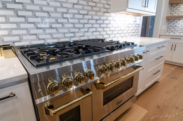 4410 Jozwiak Rd, Chappell Hill, TX 77426 - kitchen featuring range with two ovens, backsplash, light countertops, white cabinets, and light wood finished floors